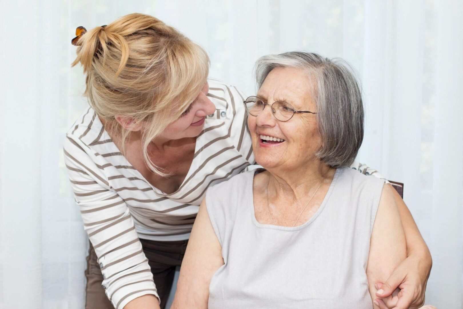 A woman is hugging an older lady