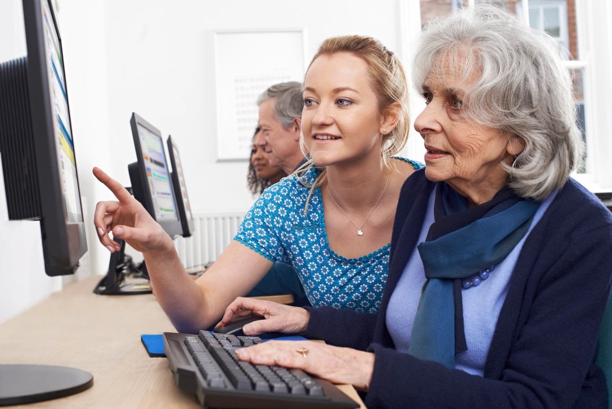 Seniors and volunteers together during a computer skills workshop.